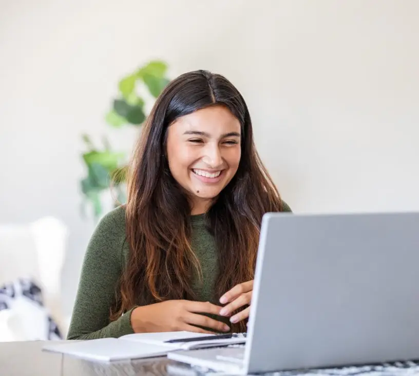 At their residence, a mother guides her high school student through a virtual assignment using the laptop.